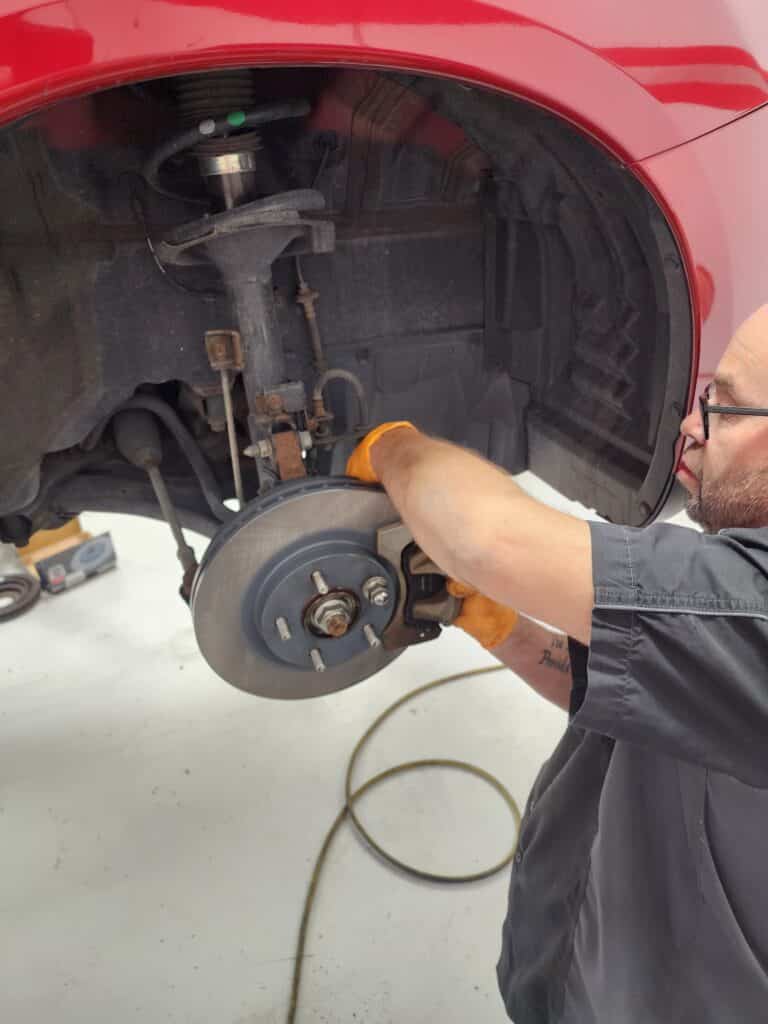 Close up disc brake without wheels of the vehicle for repair | Mac’s Complete Auto Repair