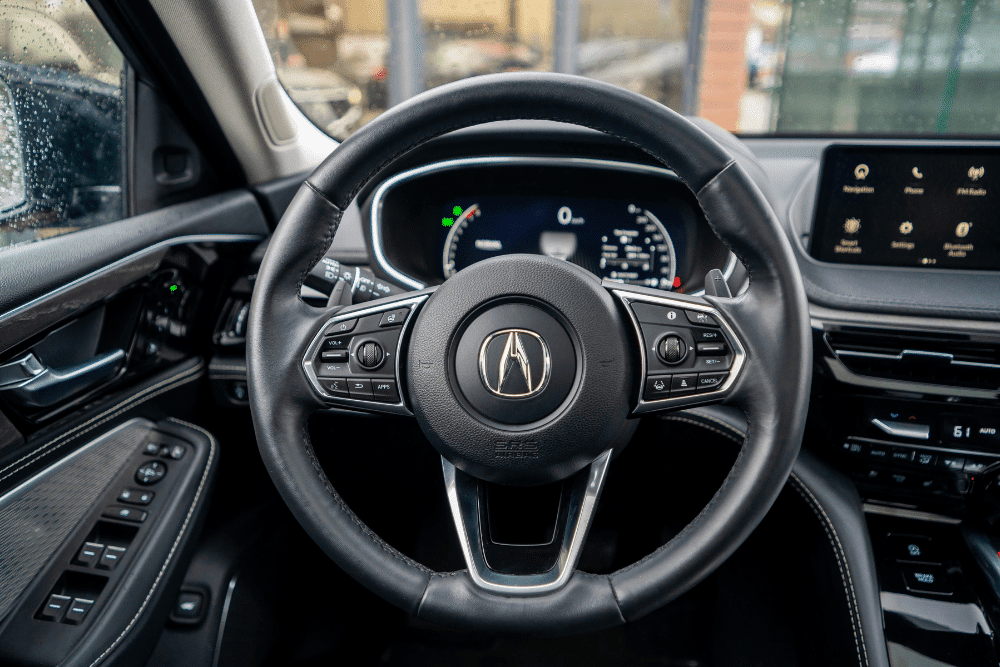 acura maintenance, auto repair in Chandler, AZ at Mac's Complete Auto Repair. Interior view of an Acura dashboard featuring a modern steering wheel with integrated controls and a digital instrument cluster.