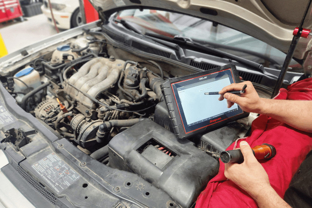 car diagnostics, auto repair in Chandler, AZ at Mac's Complete Auto Repair. Mechanic using a diagnostic scanner to troubleshoot a car engine issue.