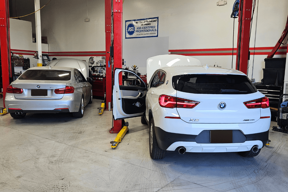 Back-to-school car maintenance in Chandler, AZ by Mac’s Complete Auto Repair. Image of two BMW vehicles in service bays, showcasing the shop’s ASE-certified technicians providing precise maintenance and repair for performance and safety.
